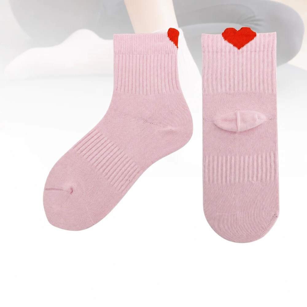 Pale-pink low-cut yoga grip socks with a red heart-shaped cuff detail