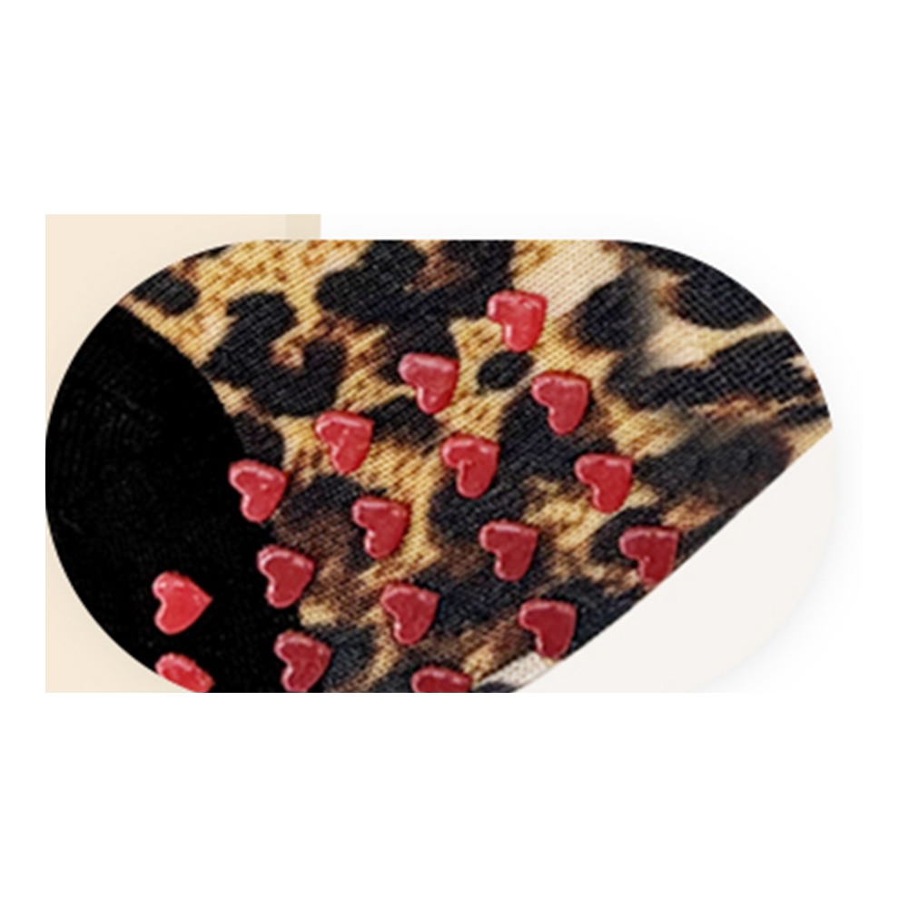 Close view of red heart-shaped sole grips on leopard-print Pilates socks