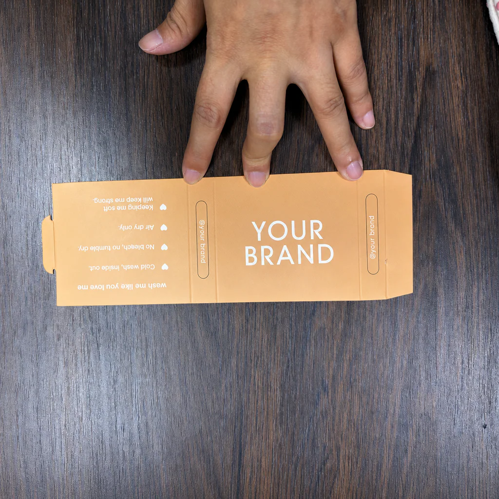 Unfolded physical custom grip sock paper sleeve sample showing front, side and care-information panels
